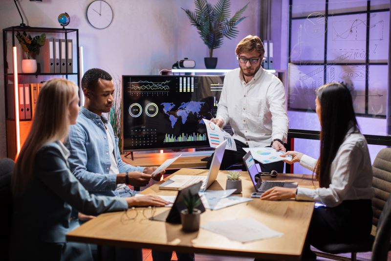 Quatro especialistas financeiros reunidos em sala de conferências para traçar estratégias que melhorem o Capital de Giro.